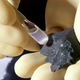 A scientist analyzing a fragment of the Murchison meteorite.